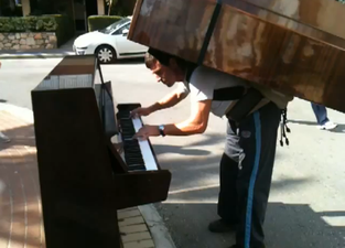 VIDEO: Man Plays Piano While Balancing Another Piano on His Back