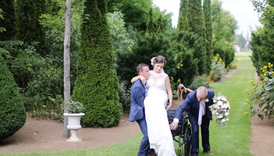 Wheelchair bound bride gets carried up the aisle by the groom