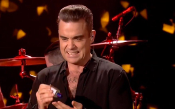 Robbie Williams has an awkward and slightly offensive moment on stage after touching a fan