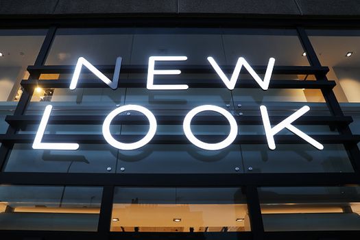 An illuminated sign hangs above the entrance to a New Look clothing retail store, owned by Brait SE, in London, U.K., on Tuesday, Dec. 12, 2017. Steinhoff International Holdings NV Chairman Christo Wiese, a major shareholder in Brait, is seeking to stabilize the embattled retailer. Photographer: Luke MacGregor/Bloomberg via Getty Images