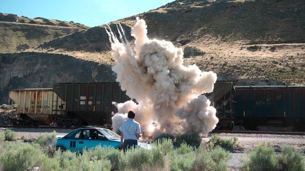 A man looks on at an explosion
