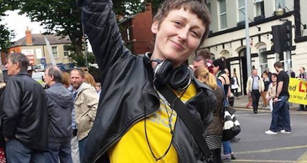 Journalist Dara Quigley poses with one arm raised