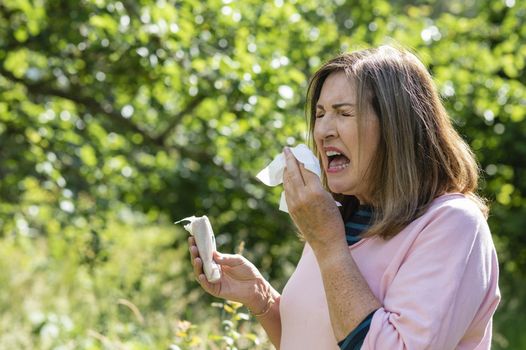 Woman sneezing because of hay fever symtpoms
